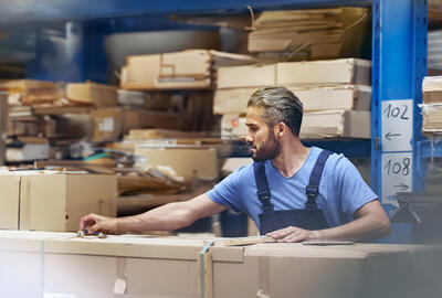 male busy with parcels in a distribution center/warehouse.
